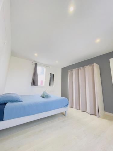 - une chambre blanche avec un lit bleu et une fenêtre dans l'établissement L'élégant de la Bascule - 4 Voyageurs - WIFI, au Mans