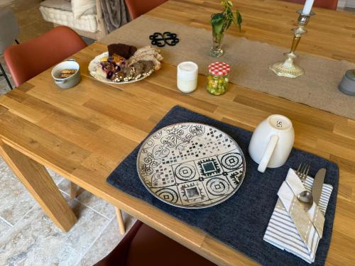 a wooden table with a plate of food on it at Les Pierres Douces in Champniers