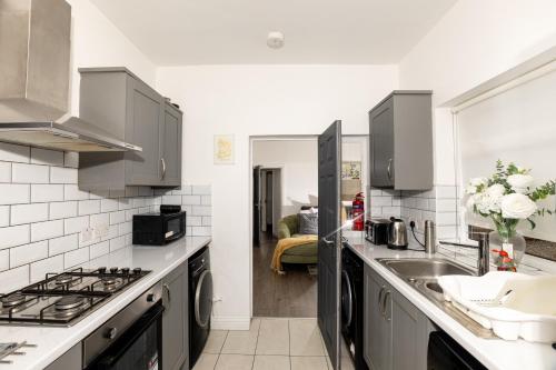 a kitchen with a sink and a stove at Priory house - home away from home in Dartford