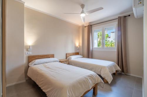 deux lits dans une chambre avec une fenêtre dans l'établissement Ponent Cala Ratjada Apartments F, à Cala Ratjada