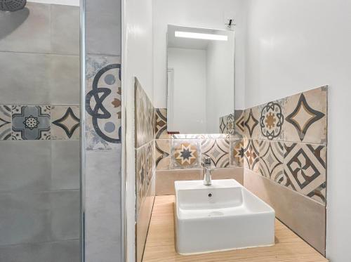 une salle de bain avec un lavabo et un miroir dans l'établissement Cosy et calme, lit double, proche transports, à Tours
