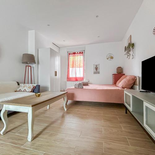 - une chambre avec un lit rose et une table dans l'établissement Cosy et calme, lit double, proche transports, à Tours