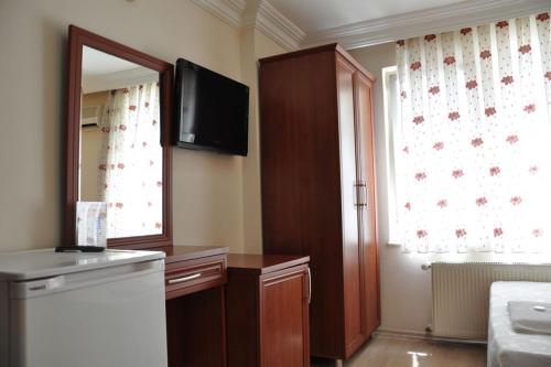 a kitchen with a refrigerator and a television on the wall at Şahin Otel1 in Samsun