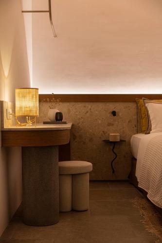 a bedroom with a bed and a desk with a lamp at Blue Rock Villa in Kalo Livadi