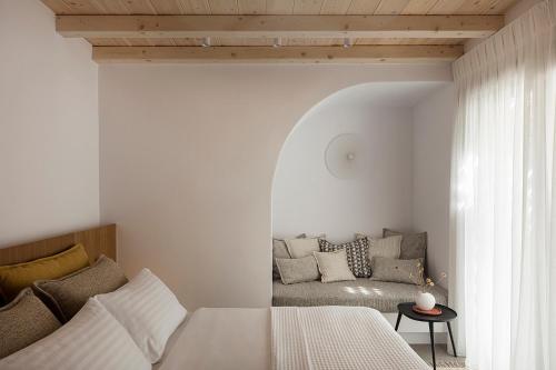 un dormitorio con una cama y un sofá en Blue Rock Villa, en Playa Kalo Livadi