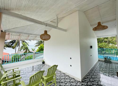 a room with green chairs and a ceiling fan at Beach bliss Arugambay in Arugam Bay