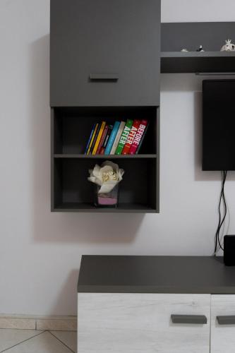 a room with a tv and a shelf with books at Amalfi Coast Holiday Home in Salerno Airport - Aeroporto di Salerno