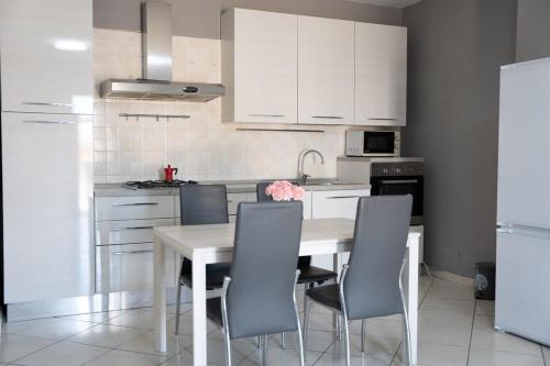 a kitchen with white cabinets and a table and chairs at Amalfi Coast Holiday Home in Salerno Airport - Aeroporto di Salerno