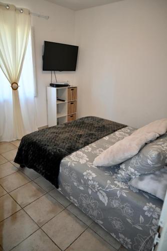 une chambre avec un lit et une télévision à écran plat dans l'établissement Villa du Soleil, à Caveirac