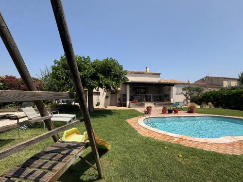 une cour arrière avec une piscine et une maison dans l'établissement La belle Ariete Arles Piscine, à Arles