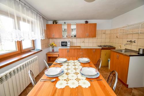 a kitchen with a wooden table with plates on it at U Lańdy in Poronin