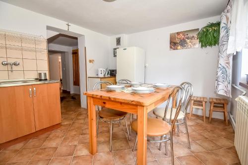 a kitchen with a wooden table and chairs at U Lańdy in Poronin