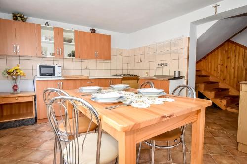 a kitchen with a wooden table and chairs at U Lańdy in Poronin