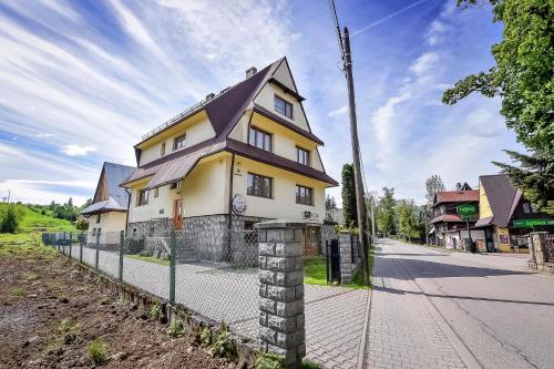 a yellow and white house with a fence at U Lańdy in Poronin