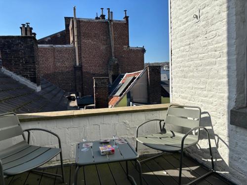 a patio with two chairs and a table on a roof at Duplex chic et spacieux - Hypercentre in Liège