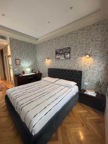 a bedroom with a large bed and two tables at Te Beu Rooms in Vlorë