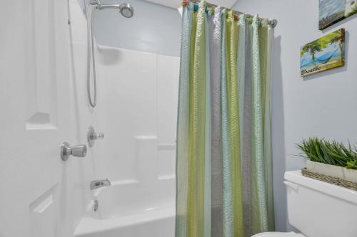 a bathroom with a shower with a shower curtain at Shorehaven Lakefront & Steps to Beach w Pool and Grill in Myrtle Beach