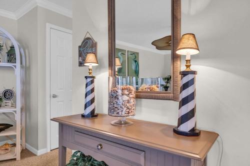 a table with two lamps and a mirror on it at Shorehaven Lakefront & Steps to Beach w Pool and Grill in Myrtle Beach