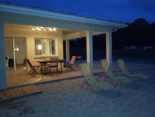 d'une terrasse avec des chaises et une table sur la plage. dans l'établissement Beach house, à Vensac
