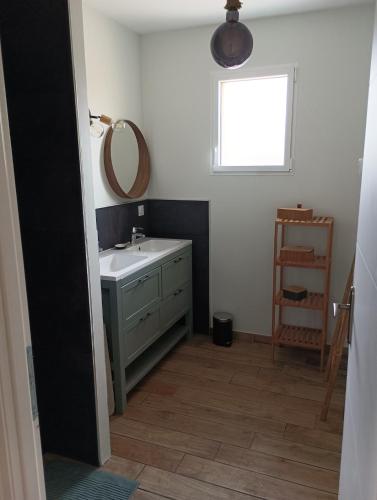 une salle de bain avec un lavabo, un miroir et une fenêtre dans l'établissement Beach house, à Vensac