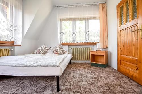 a bedroom with a bed and a dresser and a window at U Lańdy in Poronin