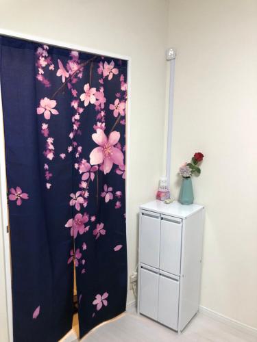 a room with a blue curtain with pink flowers at 桜屋Sakuraya201 in Tokyo