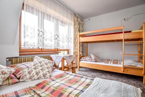a bedroom with two beds and a bunk bed at U Lańdy in Poronin