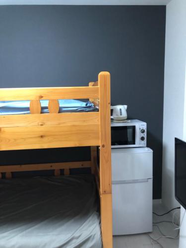 a bunk bed in a room with a microwave at 桜屋Sakuraya201 in Tokyo