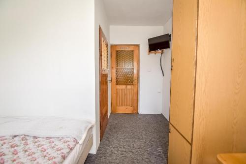 a small bedroom with a bed and a door at U Lańdy in Poronin
