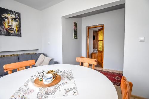 a dining room with a white table with a coffee cup on it at U Lańdy in Poronin
