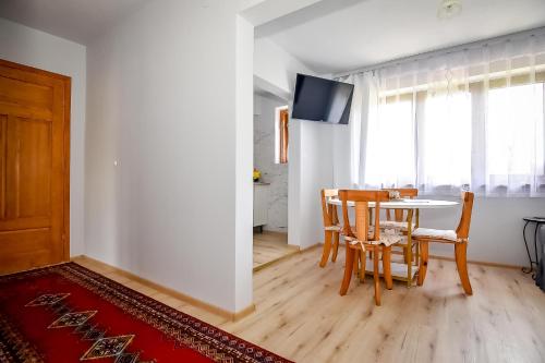 a dining room with a table and chairs and a television at U Lańdy in Poronin