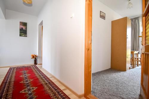 a hallway with a red rug and a white wall at U Lańdy in Poronin