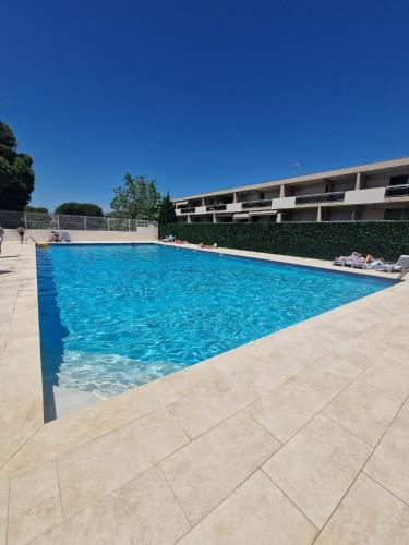 une piscine avec de l'eau bleue devant un immeuble dans l'établissement Studio Anthala Antibes proche centre avec accès piscine, à Antibes