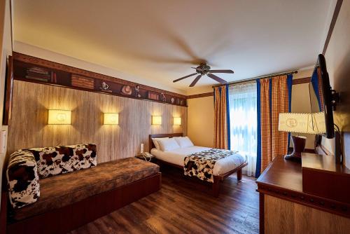 Un dormitorio con una cama y un sofá en una habitación. en Disney Hotel Cheyenne, en Coupvray