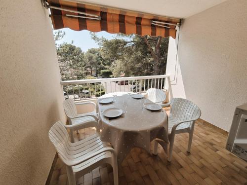 une table et des chaises sur un balcon avec une fenêtre dans l'établissement Joli studio à 350 m de la plage de Saint Asile, tout à pied., à Saint-Mandrier-sur-Mer
