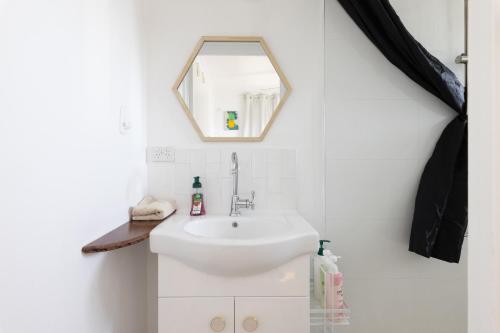 a bathroom with a sink and a mirror at Zen Escape Guest House " Location 2" - Zen Garden Tiny Home, Nooky Studio, Chillax Rest in Brisbane