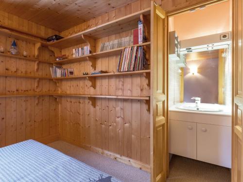 ein Badezimmer mit Holzwänden, einem Waschbecken und einem Spiegel in der Unterkunft Chalet rustique chaleureux avec cheminée à Val-d'Isère - FR-1-694-219 in Val dʼIsère