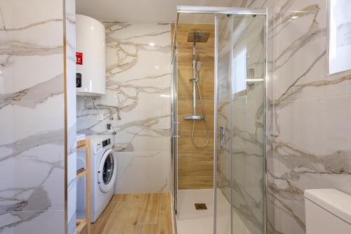 a bathroom with a shower and a washing machine at Cantinho da Estação in Bragança