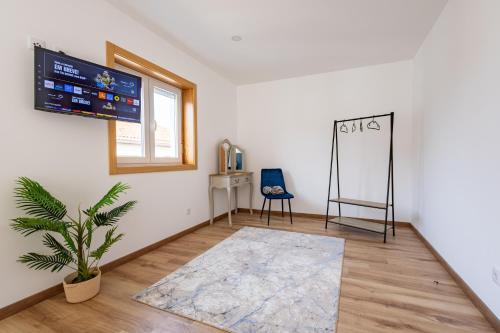 a room with a tv and a chair and a rug at Cantinho da Estação in Bragança
