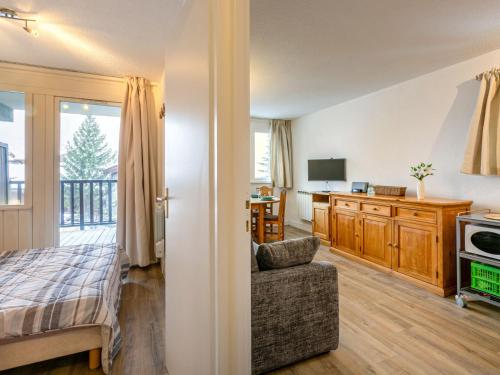 Cet appartement comprend une chambre avec un lit et un salon avec une cuisine. dans l'établissement Appartement skis aux pieds avec parking couvert et WiFi au cœur de Val d'Isère - FR-1-694-259, à Val dʼIsère
