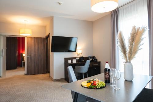 a hotel room with a table with a plate of food at Focus Hotel Premium Gdańsk in Gdańsk
