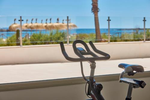 a bike parked next to a window with a view of the beach at Universal Hotel Romantica in Colonia Sant Jordi