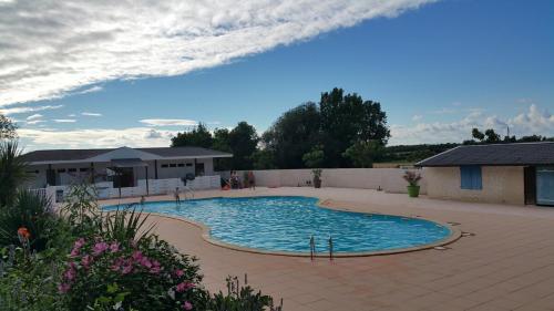 - une grande piscine dans une cour avec une maison dans l'établissement Wooden chalet, for 4 people air-conditioned, à Saint-Cyr-en-Talmondais
