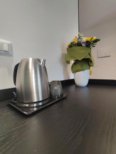 a tea kettle and a vase of flowers on a counter at Quintadecima Rooms in Palermo