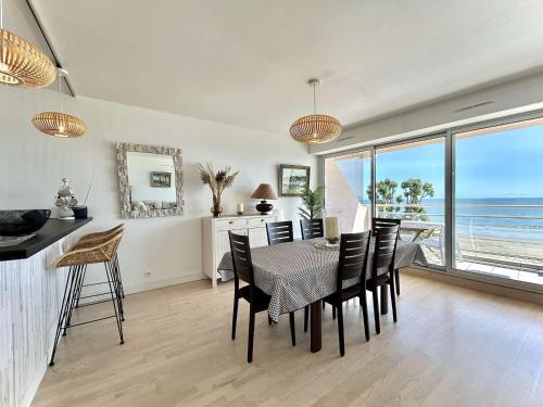 une salle à manger avec une table et des chaises et l'océan dans l'établissement Appartement 2 pièces cabine avec wifi et garage à La Baule - FR-1-245-148, à La Baule