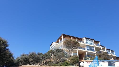 un bâtiment sur une colline avec un ciel bleu dans l'établissement Saint Pierre la mer - Nid d'aigle avec piscine à proximité de la grande plage, à Saint Pierre La Mer