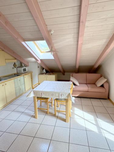 a living room with a table and a couch at Casa El Tobià in Pozza di Fassa