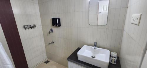 a white bathroom with a sink and a shower at 2BR Flat with Pool and Balcony near Cochin Airport in Cochin