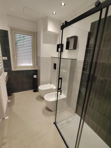 a bathroom with a toilet and a glass shower at Quintadecima Rooms in Palermo