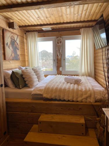 a large bed in a room with two windows at Villa INDIANA Devin in Devin